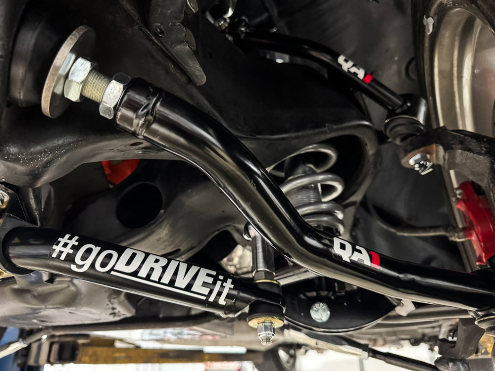 Close-up of the QA1 front suspension components, highlighting the control arms and coilovers. Close-up of the QA1 front suspension components, highlighting the control arms and coilovers.