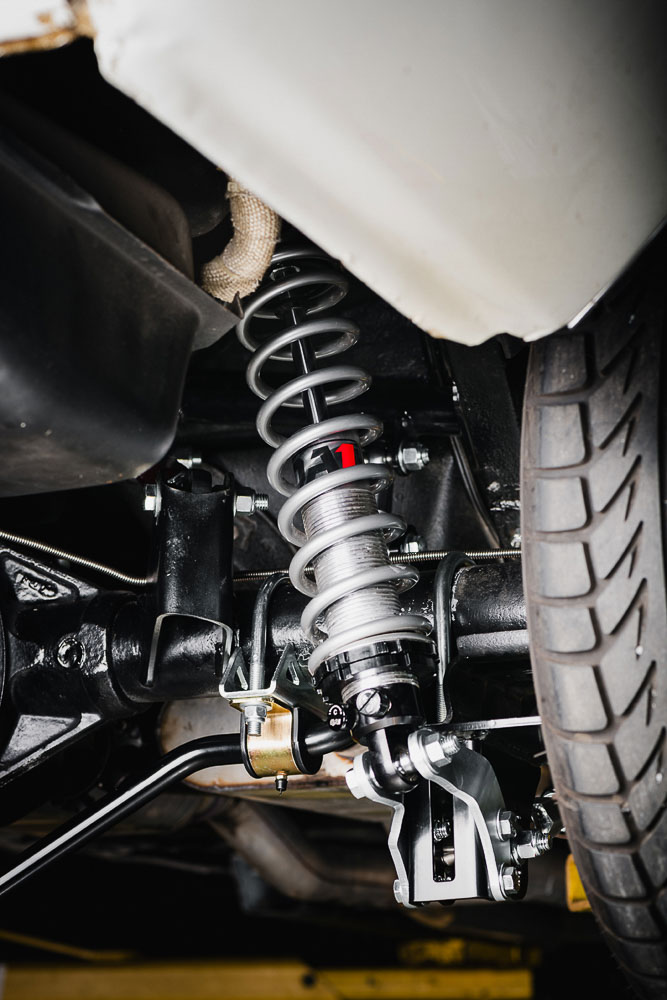 Close-up of upgraded coil-over shocks and springs installed on a Chevrolet Nova, providing adjustability for performance handling. Close-up of upgraded coil-over shocks and springs installed on a Chevrolet Nova, providing adjustability for performance handling.